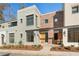 Modern townhome with light gray and brick exterior, wooden front door, and landscaping at 10871 Serenbe Ln, Chattahoochee Hills, GA 30268