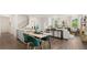 Open dining area with wooden table, green velvet chairs, and kitchen view at 600 Silver Moon Dr # 08, Loganville, GA 30052