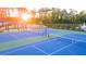 Two well-lit tennis courts with surrounding landscape and pond feature at 600 Silver Moon Dr # 08, Loganville, GA 30052