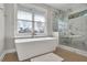 Bathroom with soaking tub, marble shower, and large window at 2334 Paces Ferry Se Rd, Smyrna, GA 30080