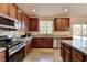 Spacious kitchen featuring dark wood cabinets and stainless steel appliances at 6121 Sparkling Cove Ln, Buford, GA 30518