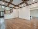 Open living room with hardwood floors, exposed beams, and a view of the entryway and kitchen at 987 Kora Sw Dr, Marietta, GA 30064