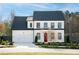 Two-story home with white siding, black trim, and a red front door at 428 10Th St, Auburn, GA 30011
