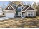 Two-story house with green and brown siding, white garage door, and landscaping at 1010 Franklin Cv, Austell, GA 30106