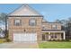 Two-story brick home with a three-car garage and landscaped lawn at 506 Se Sageton Ct, Lawrenceville, GA 30045