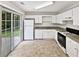 Kitchen with white cabinets, gas range, and sliding door to patio at 6674 Eastbriar Dr, Lithonia, GA 30058