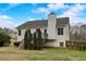 Fenced backyard with deck, chimney, and trees, under a blue sky at 76 Cedars Glen Cir, Villa Rica, GA 30180