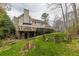 House with deck, grassy yard, fire pit, and mature trees at 380 Stone Mill Trl, Atlanta, GA 30328