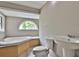 Bathroom with corner bathtub, toilet and pedestal sink at 2341 Brenda Se Dr, Smyrna, GA 30080
