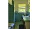 Bathroom with teal tile, bathtub, and vanity at 3321 S Norcross Tucker Rd, Tucker, GA 30084