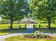 Grand estate entrance with gated driveway, lush landscaping, and a circular drive at 10955 Stroup Rd, Roswell, GA 30075