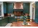 Kitchen with copper range hood and dark green cabinetry at 10955 Stroup Rd, Roswell, GA 30075