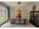 Elegant formal dining room features a large table, chandelier, and built-in hutch at 10955 Stroup Rd, Roswell, GA 30075