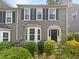 Gray two-story townhome with black door, shutters, and landscaping at 3316 Merlot Pass, Lawrenceville, GA 30044
