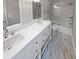 Updated bathroom with double vanity, marble flooring, and a shower/tub combo at 3316 Merlot Pass, Lawrenceville, GA 30044