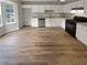 Renovated kitchen with white cabinets, granite counters, and LVP flooring at 3316 Merlot Pass, Lawrenceville, GA 30044