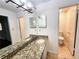Double vanity bathroom with granite countertops and separate toilet area at 8740 Roswell Rd # 9D, Atlanta, GA 30350