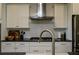 Stainless steel range hood and cooktop with white cabinets and dark countertop at 517 Whitlox Nw Rd, Atlanta, GA 30318