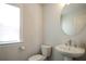 Small bathroom with pedestal sink, toilet and oval mirror at 517 Whitlox Nw Rd, Atlanta, GA 30318