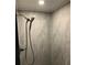 Simple shower with gray marble tile and a modern shower head at 1433 Woodland Sw Ter, Atlanta, GA 30311