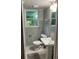 Clean bathroom with gray tile, pedestal sink and updated toilet at 1433 Woodland Sw Ter, Atlanta, GA 30311