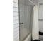 Clean bathroom with white subway tile, a white bathtub, and shower at 1433 Woodland Sw Ter, Atlanta, GA 30311