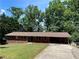 Brick ranch home with carport, red shutters, and mature trees at 5971 Robin Hood Ln, Norcross, GA 30093