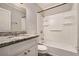 Clean bathroom featuring granite countertop vanity, shower/tub combo, and built-in shelving at 2576 Godfrey Nw Dr, Atlanta, GA 30318