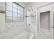 Clean bathroom with marble tile, shower, and large window at 3483 Conley St, College Park, GA 30337
