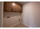 Laundry room with upper cabinets and tile flooring at 1446 Red Oak Ln, Loganville, GA 30052