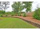 Landscaped backyard with retaining wall, privacy fence, and manicured lawn at 252 Madison Park Dr, Grayson, GA 30017