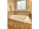Relaxing bathroom with a jetted tub and decorative window at 252 Madison Park Dr, Grayson, GA 30017