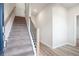 Modern staircase with black spindles and carpeted steps leading to the second floor at 2727 Harrison Dr, Lawrenceville, GA 30044