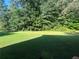 Large backyard with green lawn and mature trees at 311 Arbor Point Sw Ct, Lilburn, GA 30047