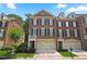 Brick three-story townhome with two-car garage and landscaped yard at 4740 Legacy Cove Ln, Mableton, GA 30126
