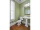 Stylish powder room with pedestal sink and wood floors at 4740 Legacy Cove Ln, Mableton, GA 30126