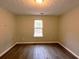 Bright bedroom featuring a window and laminate floors at 7015 Setters Way, Lithonia, GA 30038