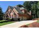Brick home with a three-car garage and manicured lawn at 319 Summer Garden Dr, Marietta, GA 30064