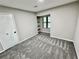 Well-lit bedroom with grey carpet and a window at 5432 Post Road Pass, Stone Mountain, GA 30088