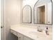Clean bathroom with double vanity, arched mirrors, and access to another room at 249 Chadwyck Ln, Canton, GA 30115