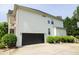Two-car garage with black doors and a side yard at 249 Chadwyck Ln, Canton, GA 30115