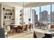 Modern dining room with large windows, hardwood floors, and a long wooden table at 40 12Th Ne St # 1005, Atlanta, GA 30309