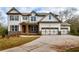 Two-story farmhouse-style home with a three-car garage and landscaping at 6175 Grindle Rd, Cumming, GA 30041