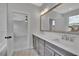 Double vanity bathroom with gray cabinets and a view into bedroom at 1356 Flora Dr, Conyers, GA 30094
