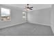 Spacious bedroom with gray carpeting, ceiling fan, and large windows at 1356 Flora Dr, Conyers, GA 30094