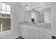 Bathroom boasts a white vanity, large mirror, and window at 1356 Flora Dr, Conyers, GA 30094