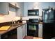 Modern kitchen with gray cabinets and black appliances at 401 16Th Nw St # 1157, Atlanta, GA 30363