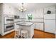 Bright kitchen with white cabinets, granite island, and stainless steel appliances at 2690 Hideaway Hills Sw Ln, Powder Springs, GA 30127