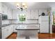 Bright kitchen with white cabinets, granite island, and stainless steel appliances at 2690 Hideaway Hills Sw Ln, Powder Springs, GA 30127