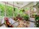 Relaxing screened porch with swing, lush plants, and ceiling fan at 2690 Hideaway Hills Sw Ln, Powder Springs, GA 30127